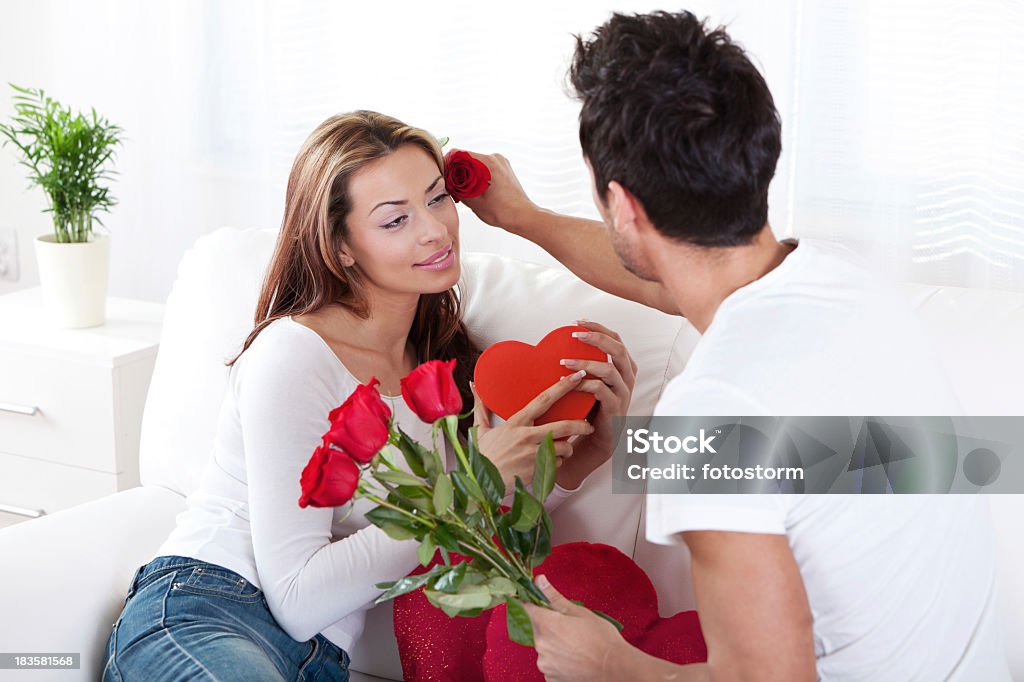 Casal romântico feliz com caixa de presente vermelho com coração e rosas - Foto de stock de 20 Anos royalty-free