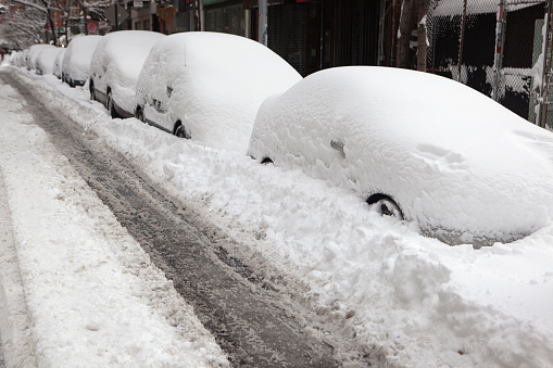 snow covered cars on a street in downtown Manhattan,NYC after a severe winter storm the previous evening.