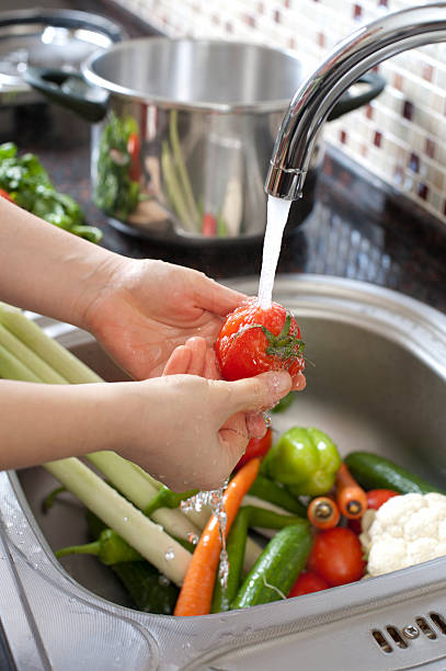 Washing Vegetables Woman washing vegetables in kitchen close up. cleaning stove domestic kitchen human hand stock pictures, royalty-free photos & images