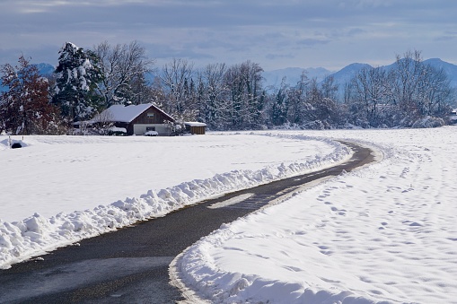 The road to the snow-covered house. Snow in the village. A lonely house under the snow. The road leads to the house in winter.
