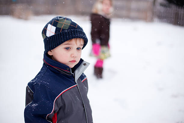 istock Little Boy Standing in Snow with Unsure Look on Face 183582436