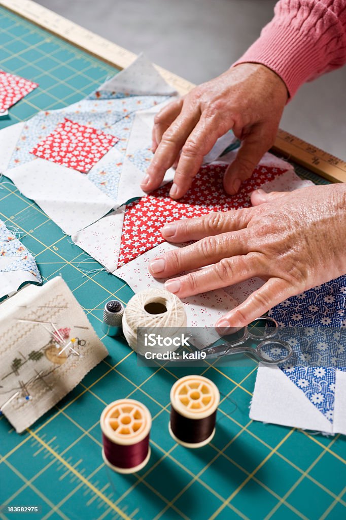Gros plan des mains de femme âgée couture de quilt - Photo de Édredon libre de droits
