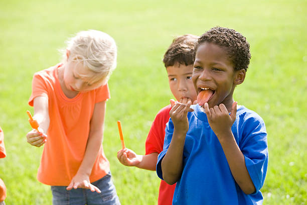 istock Multiracial young children enjoying popsicles on hot day 183583200
