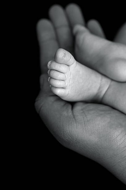 istock Newborn Feet in Dad's Hands 183583368
