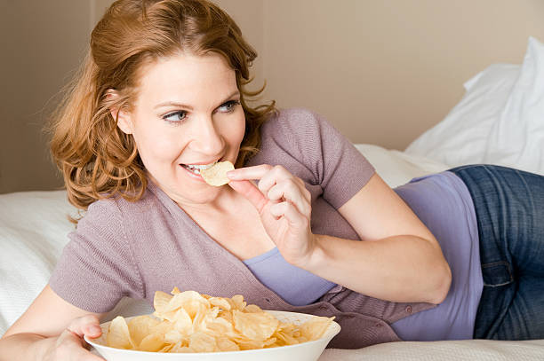 Woman with a bowl of chips stock photo