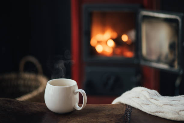 istock White cup with tea with burning fireplace on the background in cozy log cabin. 1835836410