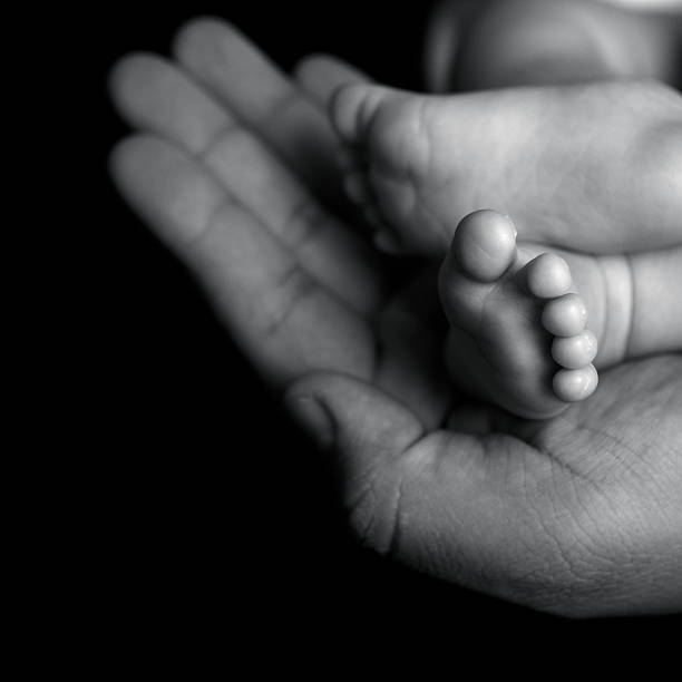 istock Newborn's Feet in Father's Hand 183584000
