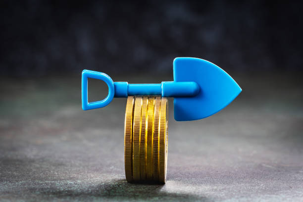 istock Some cryptocurrency coins with blue shovel on rough grunge surface 1835843451