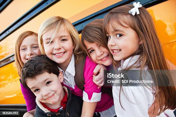 Foto de Feliz Elementar Amigos Próximo De Idade No Ônibus Escolar e mais fotos de stock de Acontecimentos da Vida
