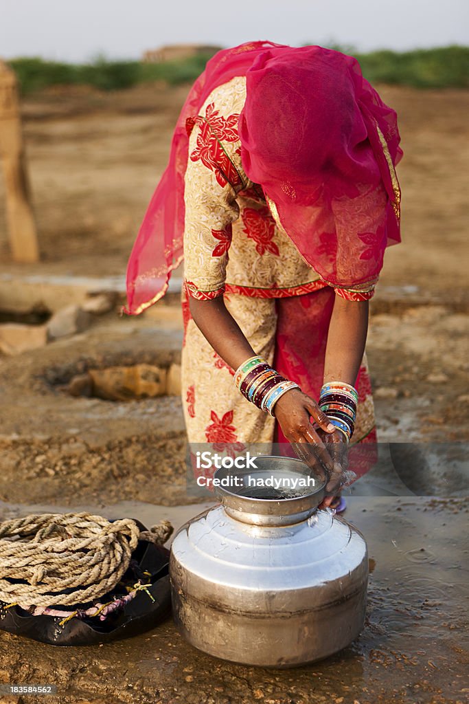 Indian mulher ficando água do bem, Rajasthan - Foto de stock de Adulto royalty-free