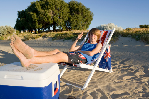 Young cheerful woman enjoying in sunbathing on the beach