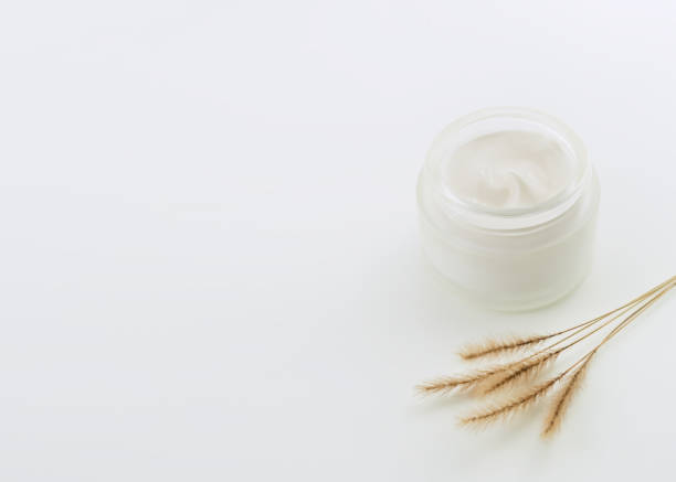 istock glass jar with moisturizing cosmetic cream and decorative dry grass on a white table 1835852428