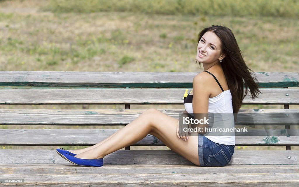 Lächelnd Mädchen sitzt auf einer Bank - Lizenzfrei Attraktive Frau Stock-Foto