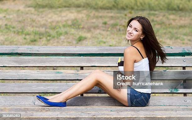 Lächelnd Mädchen Sitzt Auf Einer Bank Stockfoto und mehr Bilder von Attraktive Frau - Attraktive Frau, Braunes Haar, Eine Person