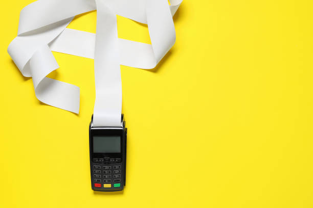 istock Payment terminal with thermal paper for receipt on yellow background, top view. Space for text 1835869218