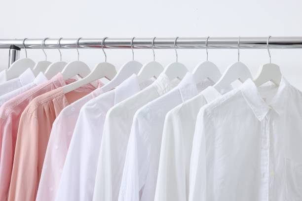 istock Rack with different stylish shirts near white wall, closeup. Organizing clothes 1835884778