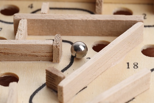 Wooden toy maze with metal ball, closeup