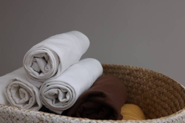 istock Different rolled clothes in basket against grey background, space for text. Organization and storage 1835885307