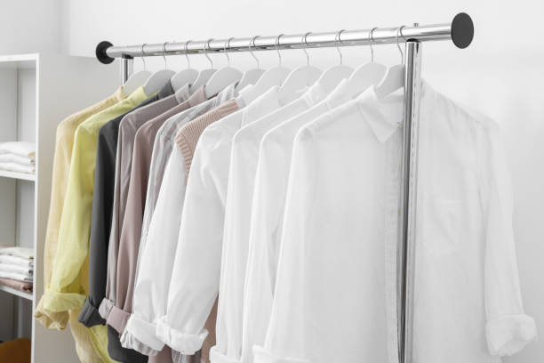istock Wardrobe organization. Rack with different stylish clothes near white wall indoors 1835888028