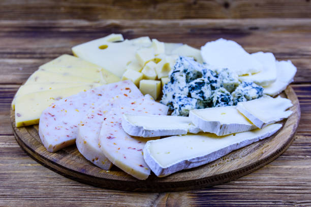plastry różnych rodzajów sera na drewnianym tle. talerz sera - cheese tray cube swiss cheese zdjęcia i obrazy z banku zdjęć