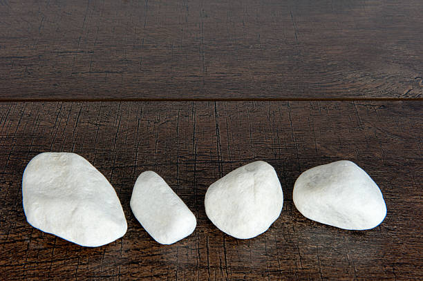 Four white rocks on brown wood stock photo