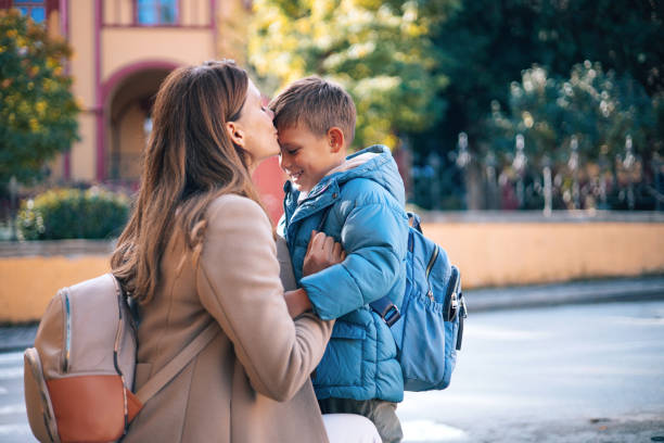 Mother stands by son on his first day at school