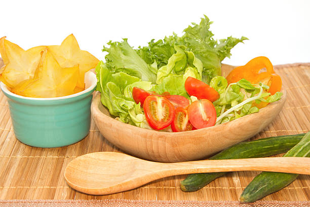 Top view of fresh green vegetable with red cherry tomato, onion and spinach with lettuce. Salad sesame dressing in wood bowl. Diet menu for food tasty and healthy meal. Flat lay, with copy space.