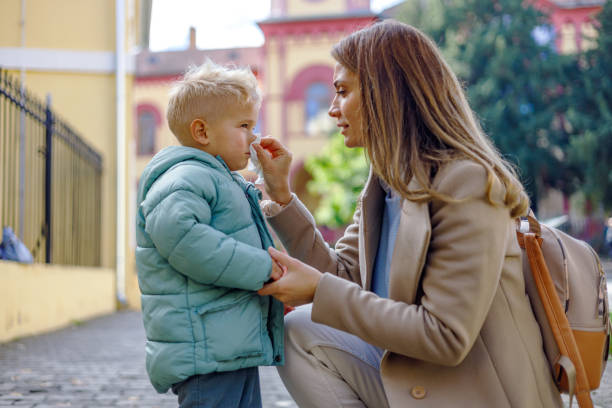 istock Mother wipes her little son's nose with affection 1835938380