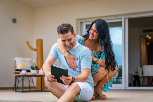 istock Woman embracing her boyfriend while using tablet outdoors 1835952827