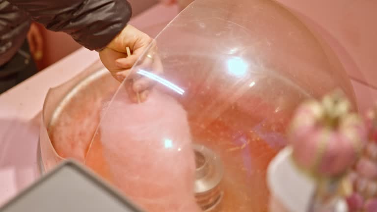 SLO MO High Angle Closeup of Unknown Vendor Making Cotton Candy at Stall in Amusement Park