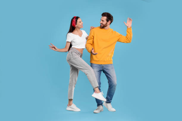 istock Happy couple dancing together on light blue background 1835981009