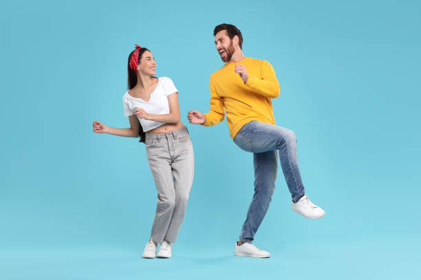 istock Happy couple dancing together on light blue background 1835982348