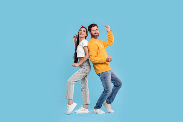 istock Happy couple dancing together on light blue background 1835982350