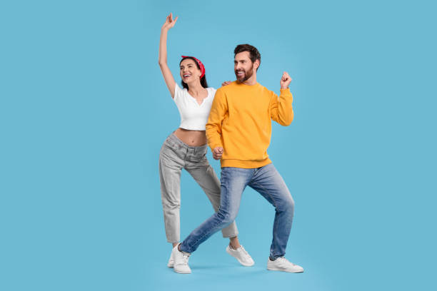 istock Happy couple dancing together on light blue background 1835982351