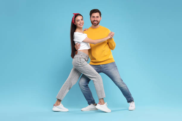 istock Happy couple dancing together on light blue background 1835982873