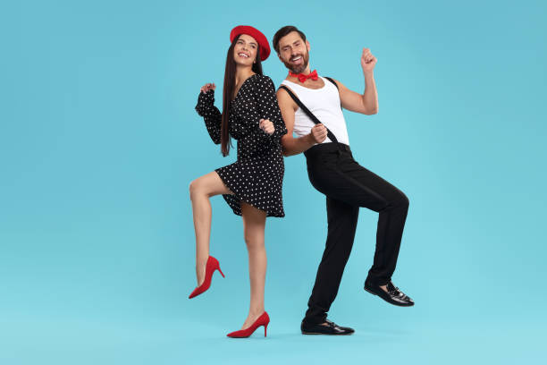 istock Happy couple dancing together on light blue background 1835982882