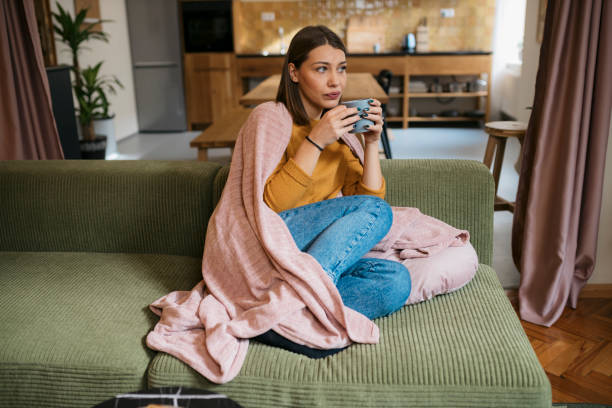 istock Sick female drinking hot warming drink while resting at home 1835986039