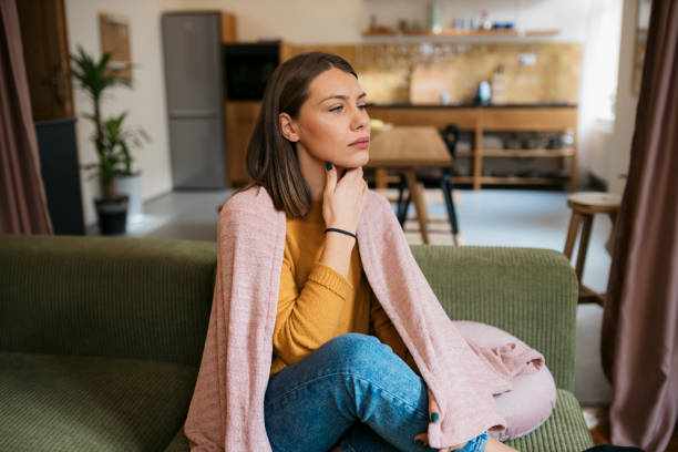 istock Ill woman having sore throat sitting on sofa 1835988660