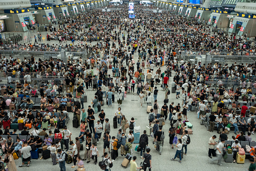 Hangzhou, Zhejiang, China - Aug 8, 2023: High angle view of passengers in the Hangzhou East Railway Station, one of the largest railway hubs in China, during the summer vacation.