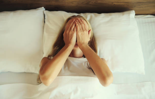 istock Upset sad crying woman covering her eyes with her hands lying on the bed on pillow while experiencing mental suffering in bedroom at home 1836008280