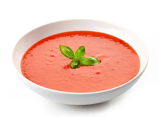 bowl of tomato soup with basil leaf