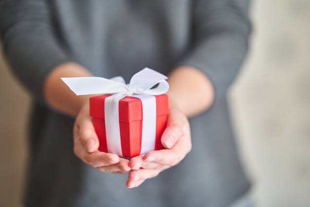 istock Woman holding small red present box in hands. 1836009310