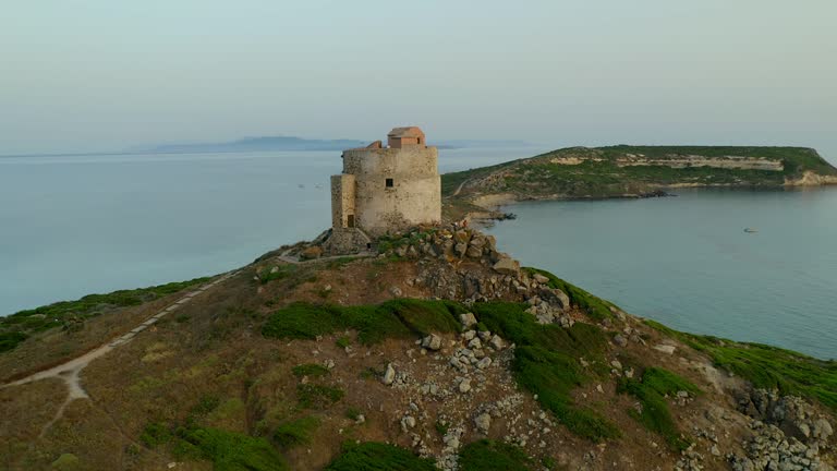 Aerial drone view of Capo San Marco cape landscape with historic San Giovanni di Sinis tower in Sardinia, Italy