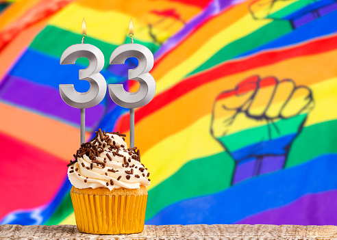 Birthday candle number 33 - Gay march flag background