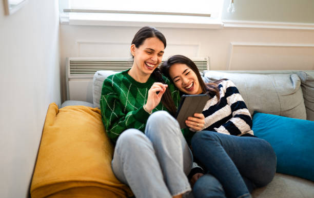 istock Lesbian couple watching funny video clips on their digital tablet 1836042043