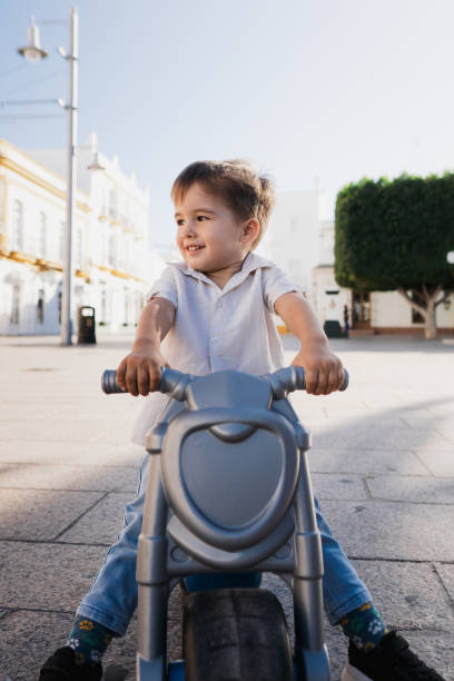 istock Little boy stops with his toy motorcycle laughing 1836042553
