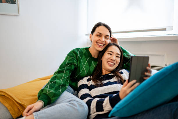 Two beautiful women using their digital tablet on the couch