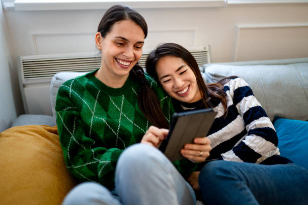istock Lesbian couple watching funny video clips on their digital tablet 1836043064