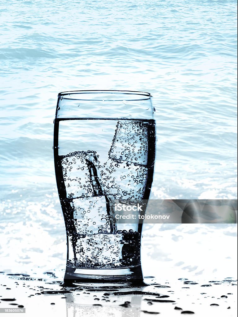 Cold purified water Cold purified water in glass with bubbles and reflection on the wet background Blue Stock Photo