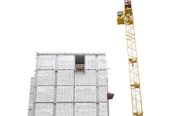 construction of a multi-storey building. construction crane and unfinished entrance to a multi-storey building against the blue sky. construction industry and business